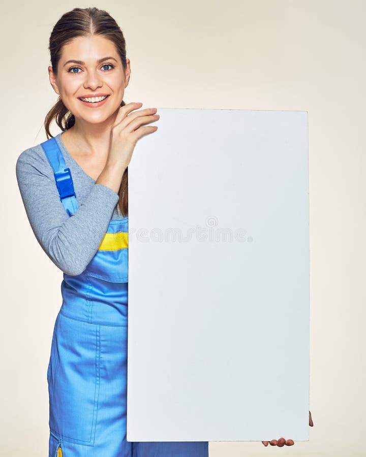 Mulher de sorriso na combinação do construtor que guarda a placa de propaganda grande imagens de stock