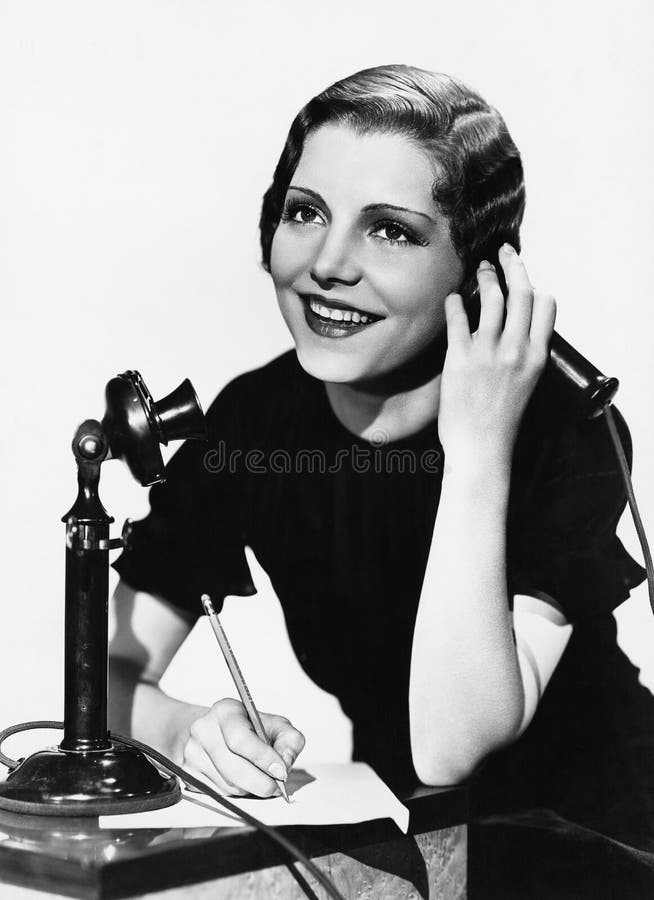 Mulher de sorriso que usa o telefone imagem de stock royalty free Mulher de sorriso que usa o telefone imagem de stock royalty free