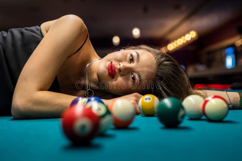 Garota sexy encontra-se na mesa de sinuca entre as bolas. jogo de