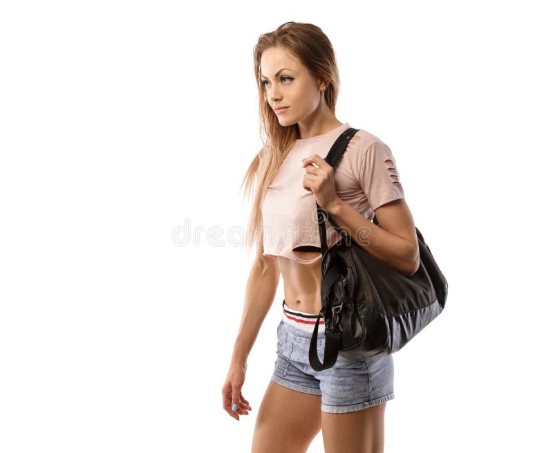 A mulher desportiva bonita com saco dos esportes vai à formação, isolada no branco fotografia de stock royalty free A mulher desportiva bonita com saco dos esportes vai à formação, isolada no branco fotografia de stock royalty free
