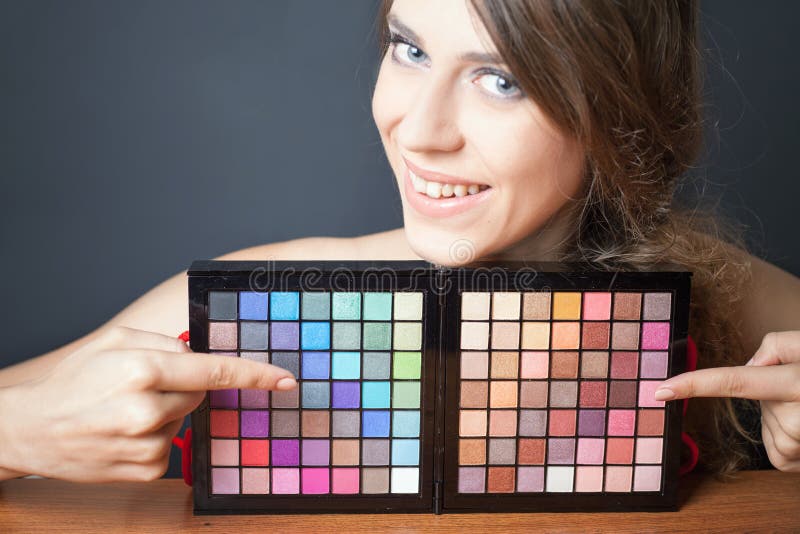 Mulher do encanto que aponta na paleta colorida para a composição da forma fotografia de stock royalty free Mulher do encanto que aponta na paleta colorida para a composição da forma fotografia de stock royalty free