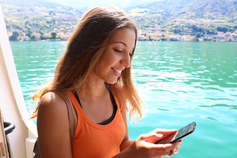 Mulher do navio de cruzeiros que usa o telefone celular em férias do curso Sms texting da menina ou utilização do Internet de Wif imagens de stock Mulher do navio de cruzeiros que usa o telefone celular em férias do curso Sms texting da menina ou utilização do Internet de Wif imagens de stock