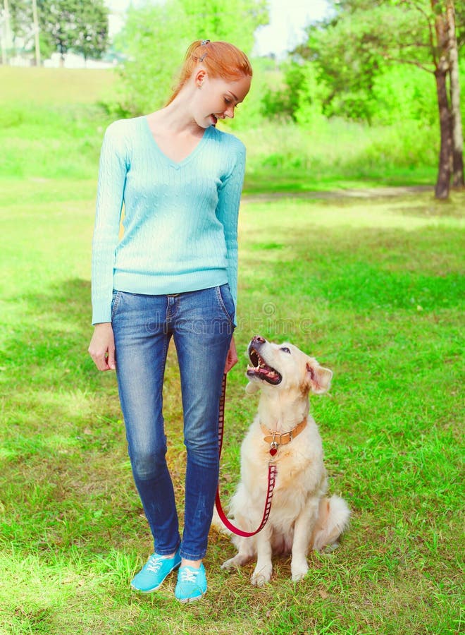 a mulher do proprietário e o cão do golden retriever são olhar em se caminhada imagem de stock a mulher do proprietário e o cão do golden retriever são olhar em se caminhada imagem de stock