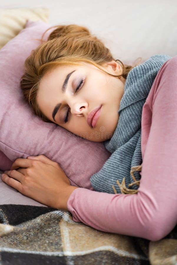 Mulher doente com cachecol cinza dormindo na cama fotografia de stock royalty free