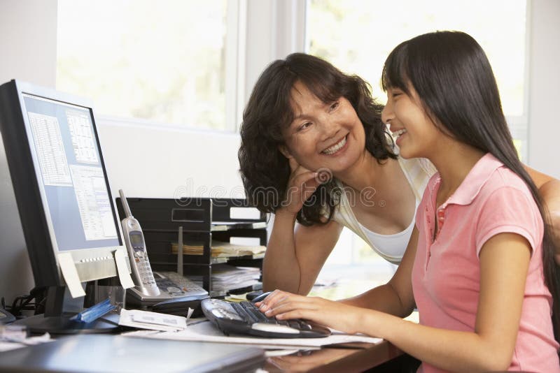 Mulher e filha adolescente que usa o computador imagens de stock Mulher e filha adolescente que usa o computador imagens de stock