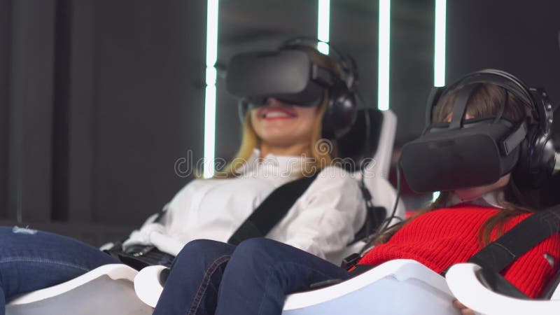 Mulher e garotinha com óculos vr dirigem simulador de realidade virtual