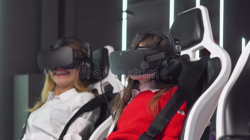 Mulher e garotinha com óculos vr dirigem simulador de realidade virtual