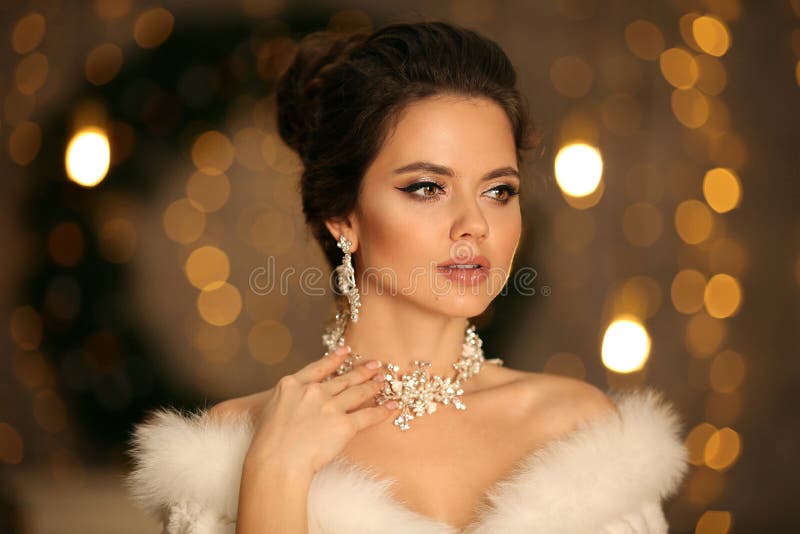 Mulher elegante com pele branca. retrato de moda de inverno de bela noiva jovem com brincos de diamante e joias de colar.