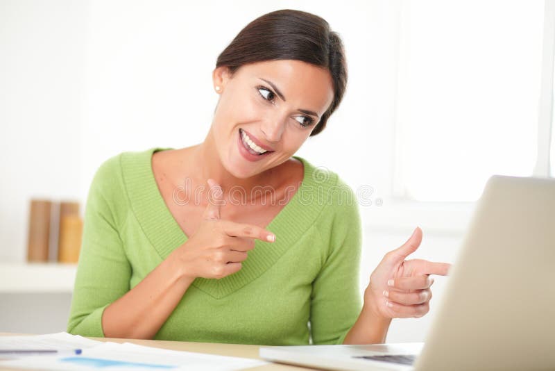 Mulher elegante que olha alegremente ao trabalhar imagem de stock Mulher elegante que olha alegremente ao trabalhar imagem de stock