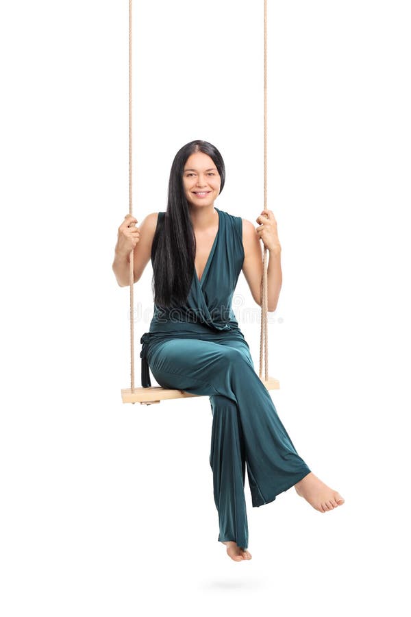 Mulher elegante que senta-se em um balanço imagem de stock Mulher elegante que senta-se em um balanço imagem de stock