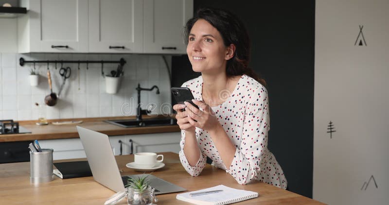 Mulher em pé na cozinha smartphone desfruta de um chat agradável online