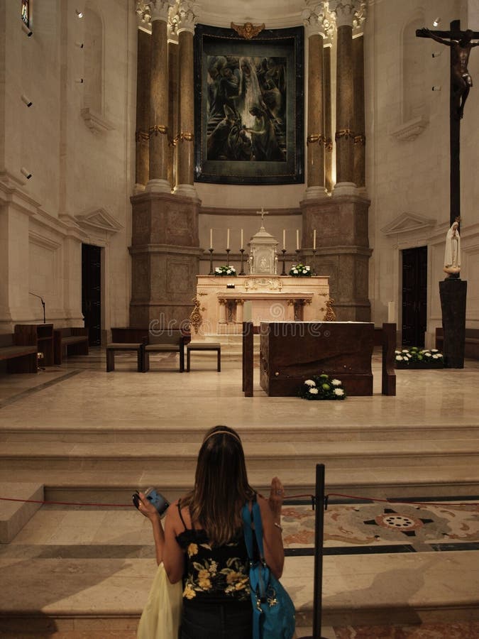 MULHER EM SEUS JOELHOS QUE REZA O INTERIOR BASÍLICO fotografia de stock MULHER EM SEUS JOELHOS QUE REZA O INTERIOR BASÍLICO fotografia de stock