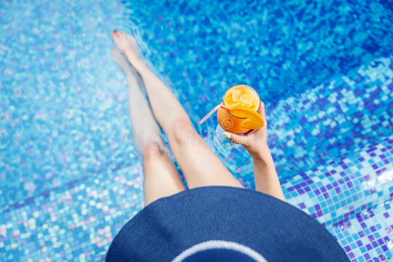 Mulher em um chapéu azul que relaxa na associação com um cocktail fotografia de stock Mulher em um chapéu azul que relaxa na associação com um cocktail fotografia de stock