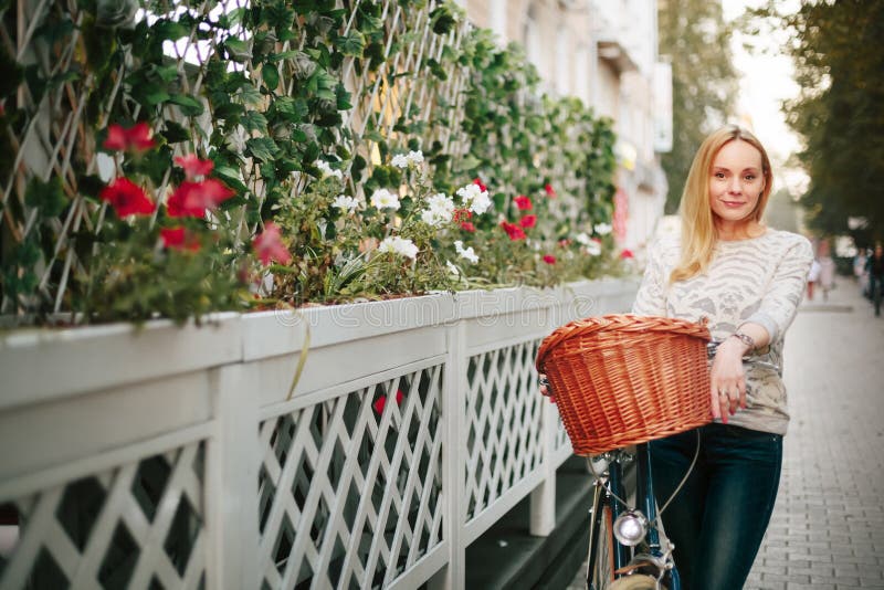 Mulher em uma bicicleta do vintage na rua foto de stock Mulher em uma bicicleta do vintage na rua foto de stock