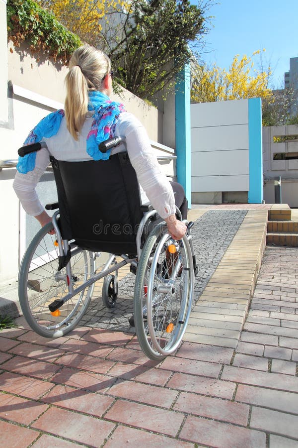Mulher em uma cadeira de rodas em uma rampa da cadeira de rodas