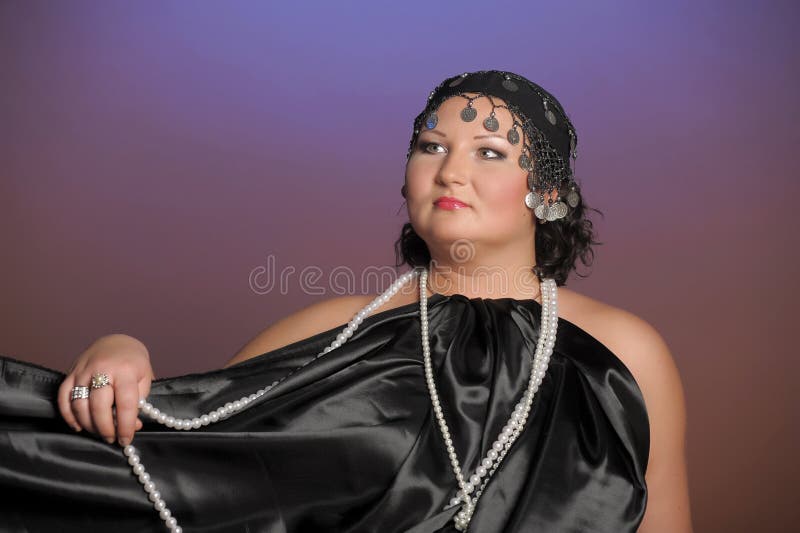 Woman in oriental robes in black with pearls around her neck. Woman in oriental robes in black with pearls around her neck