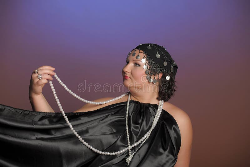 Woman in oriental robes in black with pearls around her neck. Woman in oriental robes in black with pearls around her neck