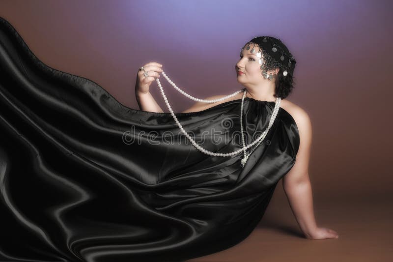 Woman in oriental robes in black with pearls around her neck. Woman in oriental robes in black with pearls around her neck