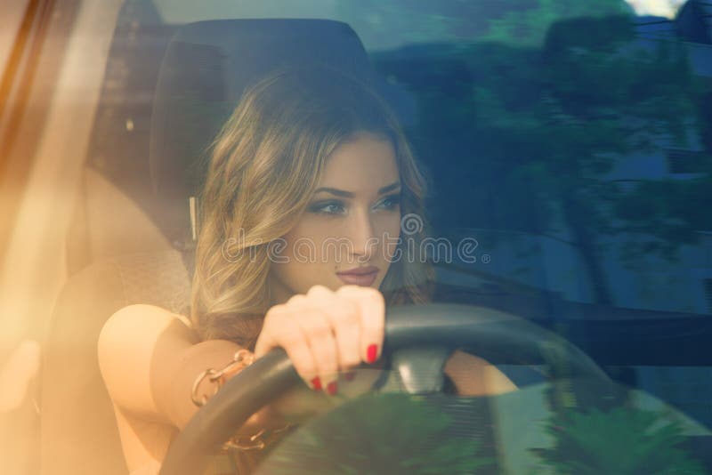 Mulher encantador que conduz o carro e que olha afastado imagens de stock Mulher encantador que conduz o carro e que olha afastado imagens de stock