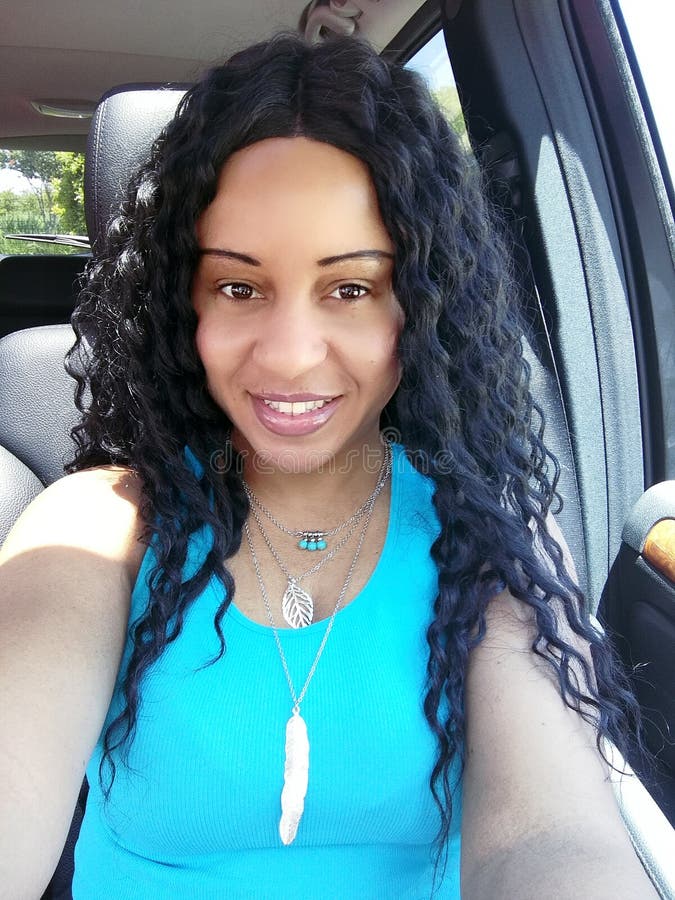 Mulher encaracolado bonita do cabelo preto que conduz um carro imagem de stock Mulher encaracolado bonita do cabelo preto que conduz um carro imagem de stock