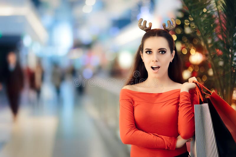 Mulher engraçada com compra da faixa dos chifres da rena do Natal imagens de stock