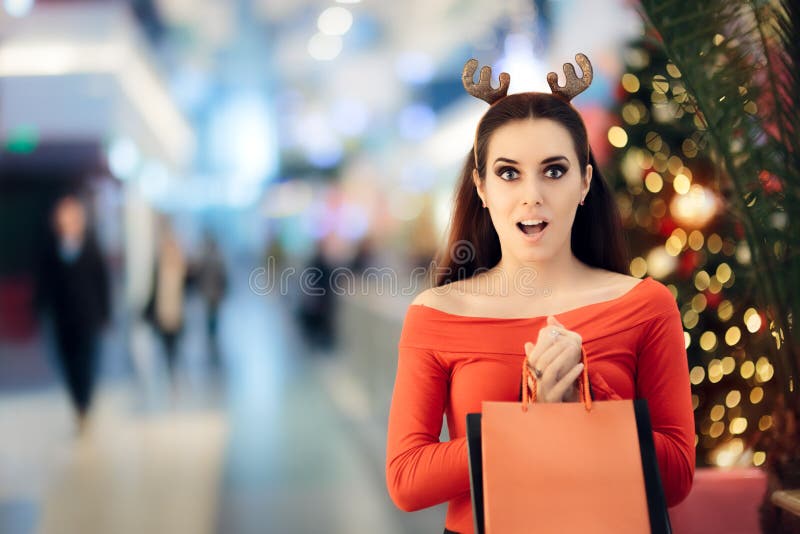 Mulher engraçada com compra da faixa dos chifres da rena do Natal imagens de stock royalty free