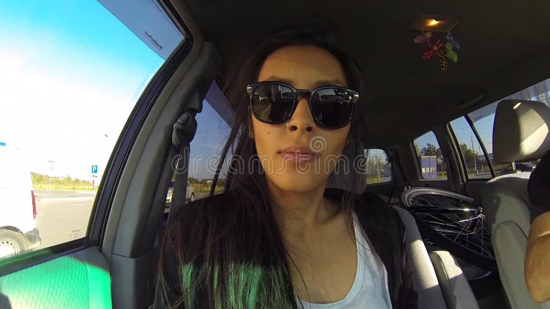 Mulher engraçada que faz Selfie com o GoPro dentro da viagem do carro