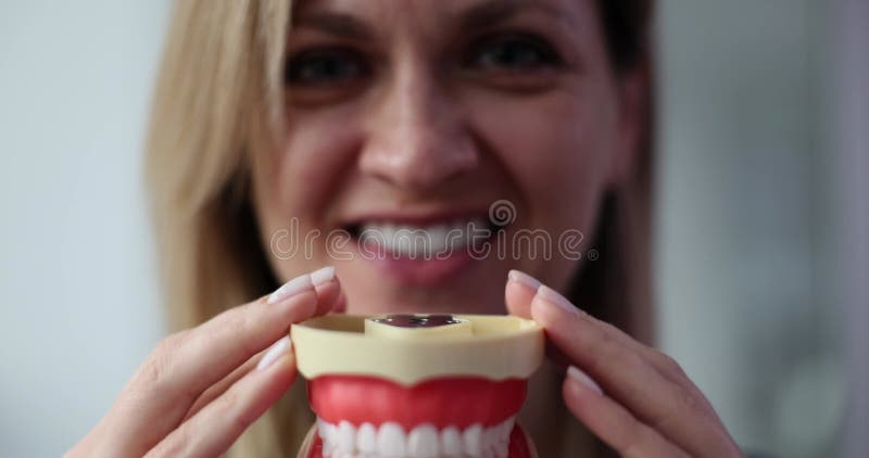 Mulher engraçada segurando mandíbula mostrando lindos dentes brancos saudáveis