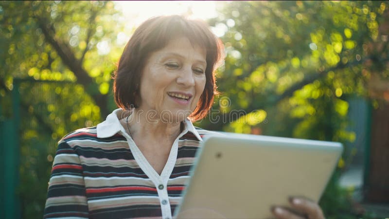 Mulher envelhecida que fala por Skype vídeos de arquivo