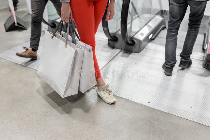 A mulher feliz bonita de Shopaholic vai comprar na cidade Moça em calças vermelhas e em muitos sacos de papel cinzentos ela fotos de stock A mulher feliz bonita de Shopaholic vai comprar na cidade Moça em calças vermelhas e em muitos sacos de papel cinzentos ela fotos de stock