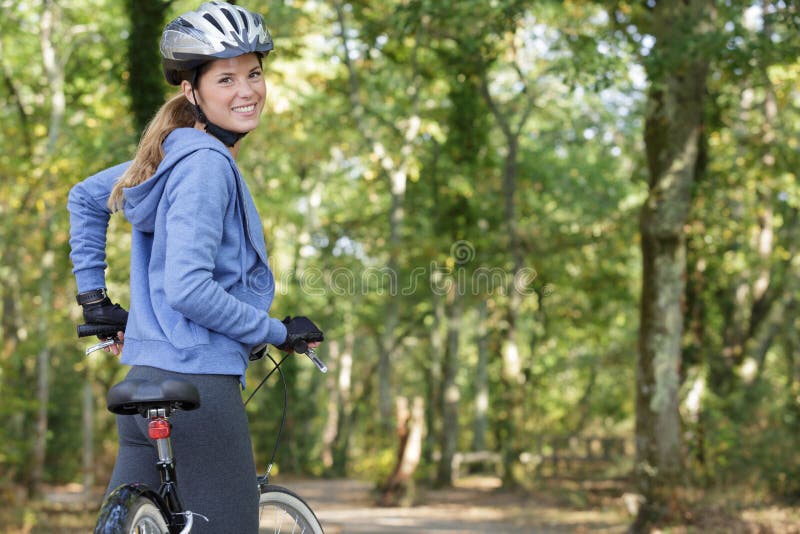 Mulher ciclista feliz a olhar para trás fotografia de stock