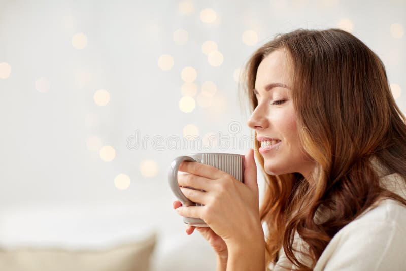 Mulher feliz com o copo do chá ou do café em casa imagens de stock Mulher feliz com o copo do chá ou do café em casa imagens de stock