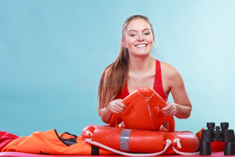 Mulher feliz da salva-vidas que encontra-se na boia de anel do salvamento foto de stock Mulher feliz da salva-vidas que encontra-se na boia de anel do salvamento foto de stock