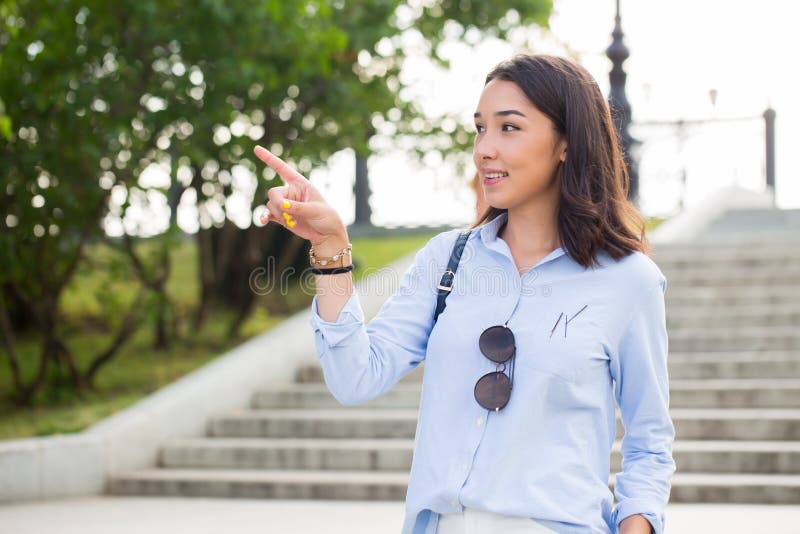 Mulher feliz de sorriso que aponta o dedo ao lado com uma expressão brincalhão imagens de stock Mulher feliz de sorriso que aponta o dedo ao lado com uma expressão brincalhão imagens de stock