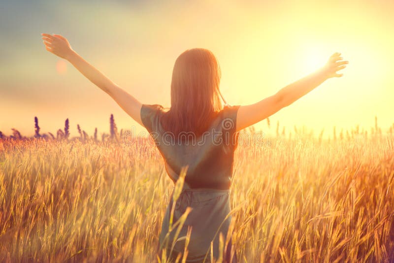 Mulher feliz do outono levantando mãos sobre o céu do pôr do sol, aproveitando a vida e a natureza Bela fêmea no campo olhando pa