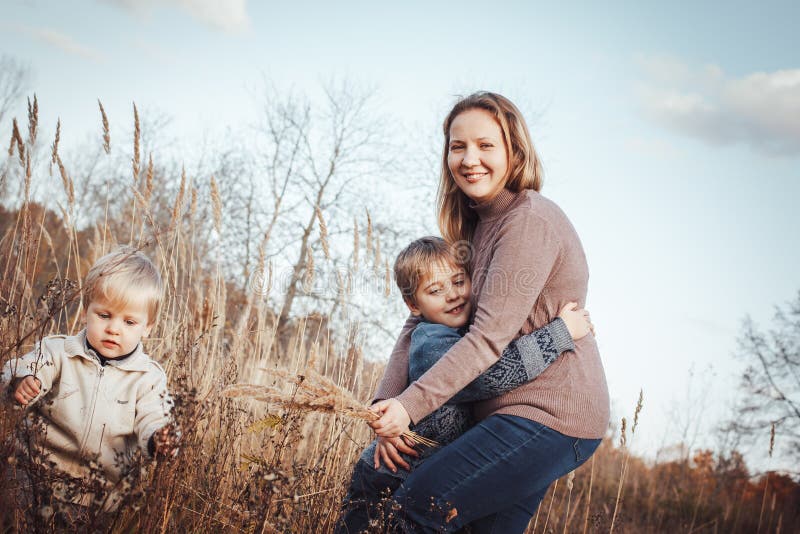 Mulher feliz e dois filhos em um campo em um outono foto de stock royalty free Mulher feliz e dois filhos em um campo em um outono foto de stock royalty free