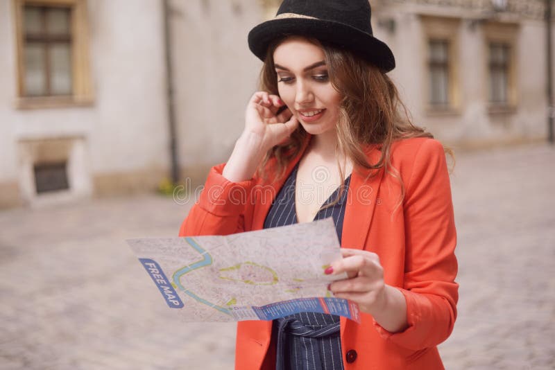 A mulher feliz em férias com mapa, viajante anda a cidade Dia ensolarado Vista traseira Uma mulher nova do turista em um chapéu, fotografia de stock A mulher feliz em férias com mapa, viajante anda a cidade Dia ensolarado Vista traseira Uma mulher nova do turista em um chapéu, fotografia de stock