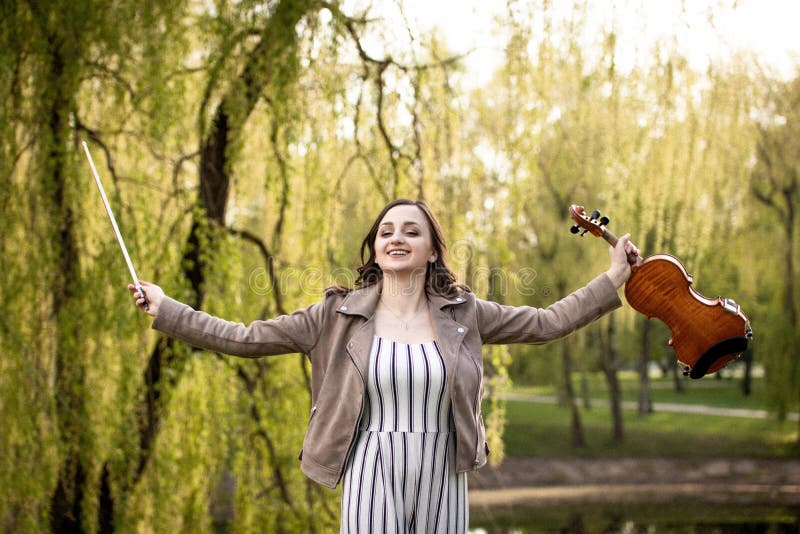 Mulher feliz nova com violino e curva fotografia de stock Mulher feliz nova com violino e curva fotografia de stock