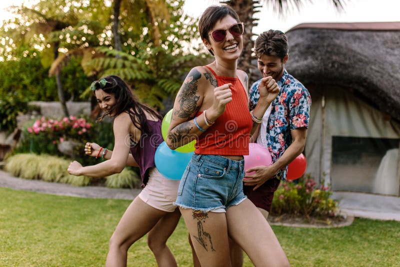 Mulher feliz que aprecia com os amigos que jogam jogos foto de stock Mulher feliz que aprecia com os amigos que jogam jogos foto de stock