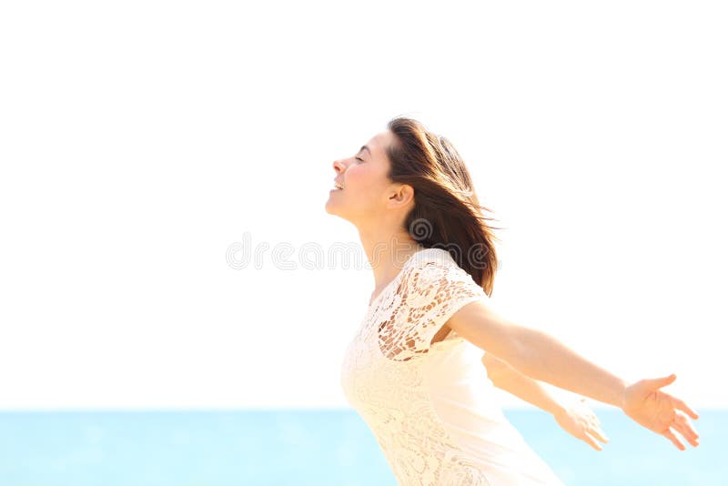 Happy woman enjoying the wind and breathing fresh air on the beach in a sunny and windy day. Happy woman enjoying the wind and breathing fresh air on the beach in a sunny and windy day