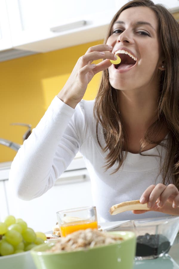 Mulher feliz que faz o pequeno almoço foto de stock Mulher feliz que faz o pequeno almoço foto de stock