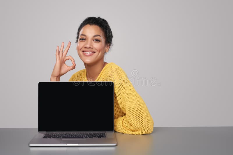Mulher feliz que mostra a tela preta vazia do comuter imagem de stock Mulher feliz que mostra a tela preta vazia do comuter imagem de stock