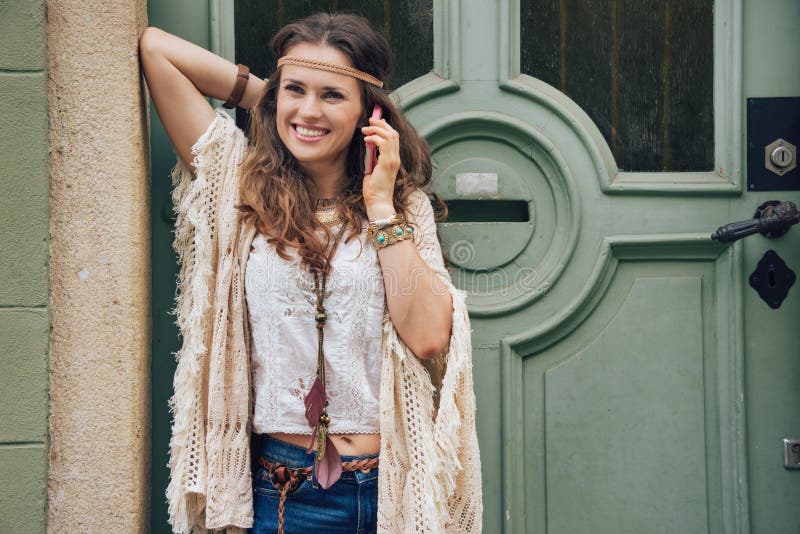 A mulher feliz que veste o estilo boêmio veste o telefone celular de fala imagens de stock A mulher feliz que veste o estilo boêmio veste o telefone celular de fala imagens de stock