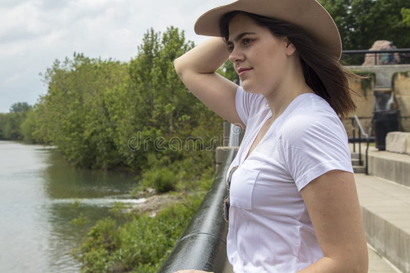 Mulher forte ao lado do rio com chapéu imagem de stock Mulher forte ao lado do rio com chapéu imagem de stock