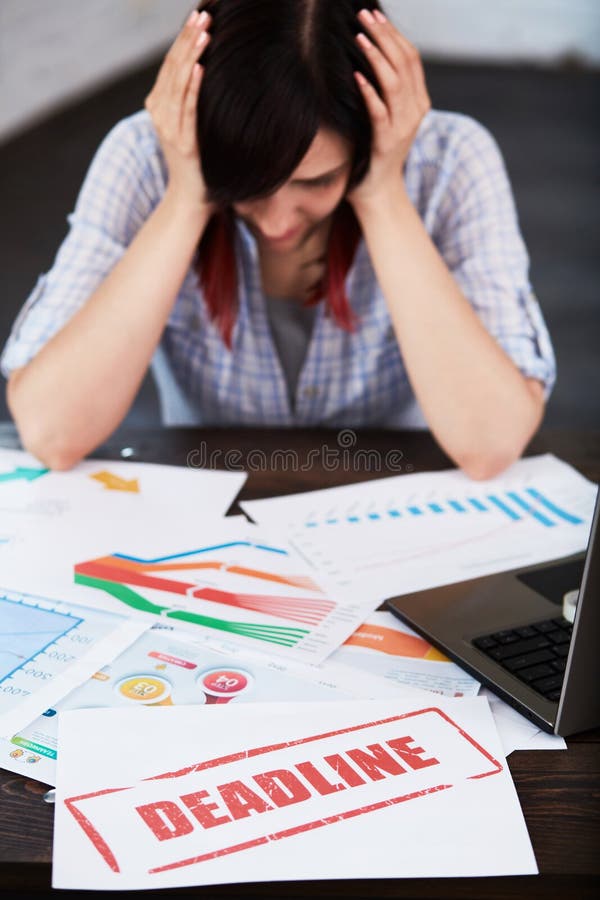 Mulher forçada no escritório que pensa sobre o fim do prazo imagens de stock royalty free Mulher forçada no escritório que pensa sobre o fim do prazo imagens de stock royalty free
