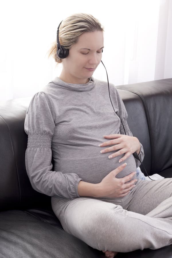 Mulher Gravida Que Joga a Música a Seu Bebê Foto de Stock - Imagem de jogar,  cabelo: 22717502