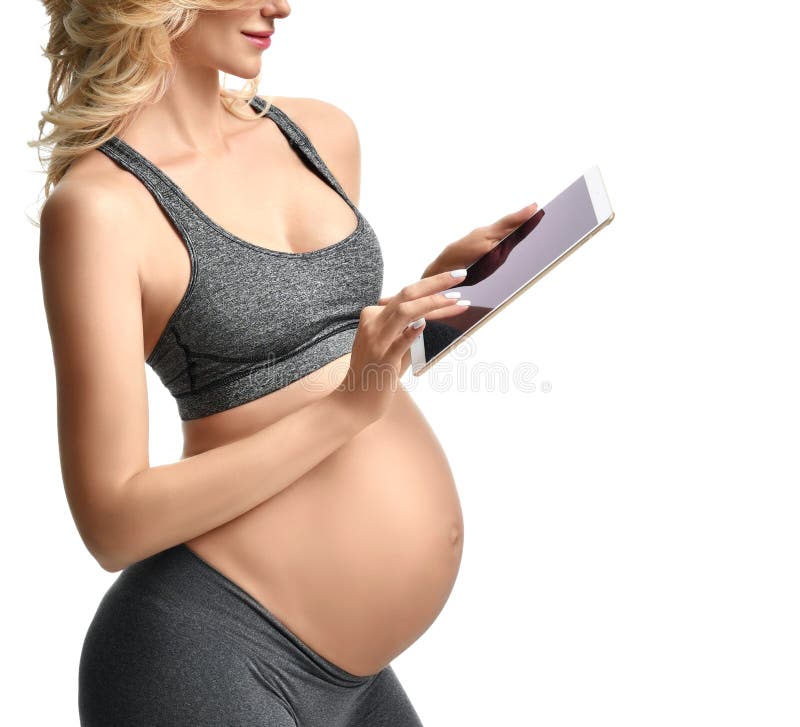 Mulher gravida bonita com aplicação grande da expectativa da maternidade da gravidez do uso da barriga que datilografa na almofad imagem de stock Mulher gravida bonita com aplicação grande da expectativa da maternidade da gravidez do uso da barriga que datilografa na almofad imagem de stock