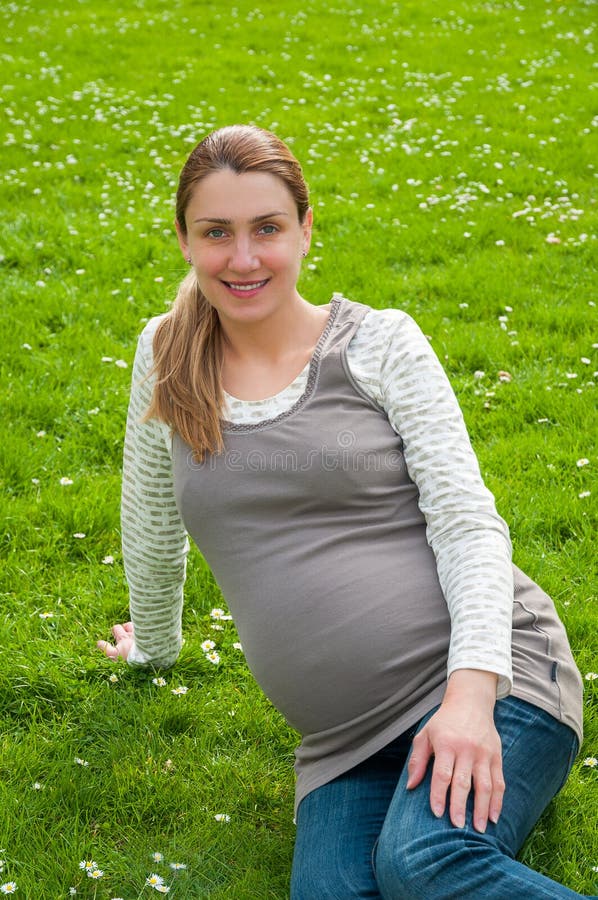Mulher gravida bonita que relaxa no parque foto de stock Mulher gravida bonita que relaxa no parque foto de stock