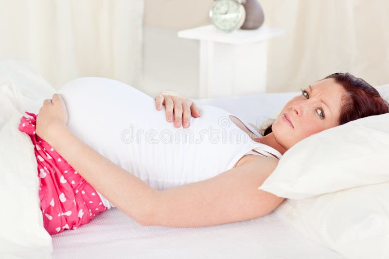 Mulher gravida caucasiano que descansa em sua cama foto de stock Mulher gravida caucasiano que descansa em sua cama foto de stock