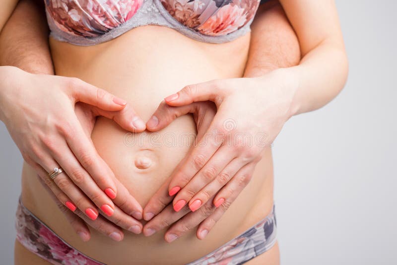 Mulher gravida e seu marido que guardam a colisão do bebê foto de stock Mulher gravida e seu marido que guardam a colisão do bebê foto de stock